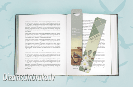 Atvērta grāmata ar tekstu un divām dizaina grāmatzīmēm uz gaiši zila fona