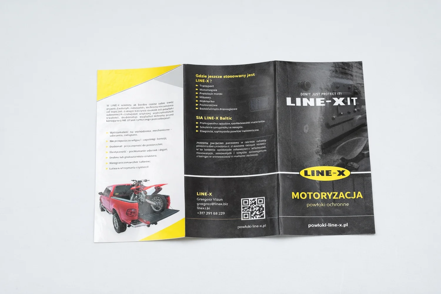 Open LINE-X brochure on a gray background with car images and text in Polish