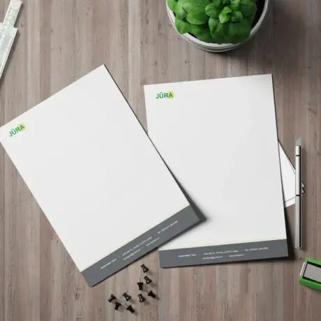 Custom letterhead printing sample with company logo and details on a wooden desk