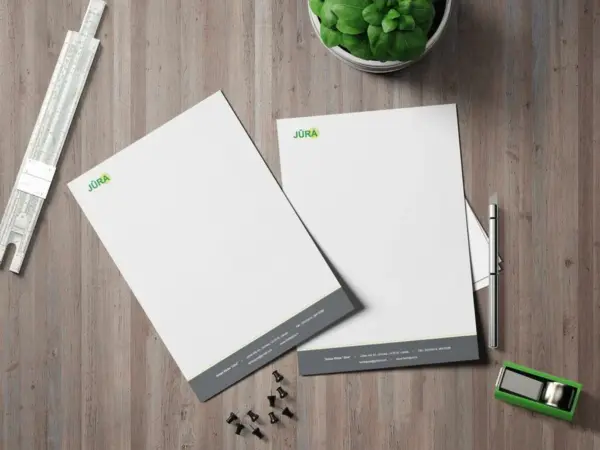 Custom letterhead printing sample with company logo and details on a wooden desk