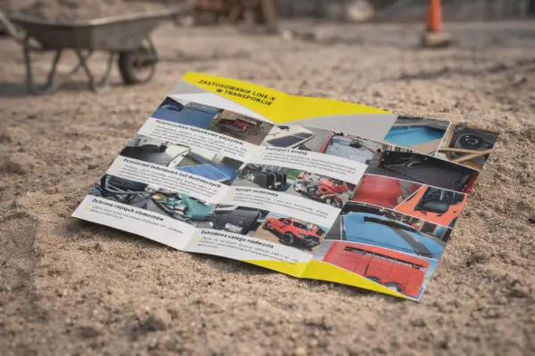 Atvērts buklets uz smiltīm kā bukletu izgatavošanas un drukas paraugs