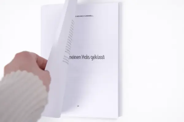 Рука перелистывает страницу в качественно напечатанной книге в мягкой обложке