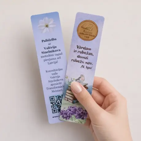 Hand holding custom bookmark printing samples with individual design and illustrations