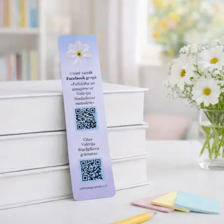 Custom bookmark printing sample with QR codes and floral design by a stack of white books