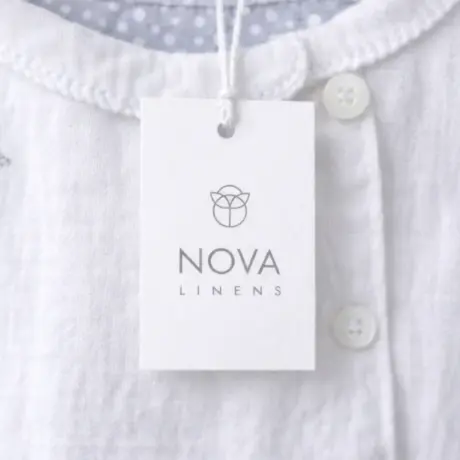 White custom hang tag with NOVA LINENS print and string on clothing