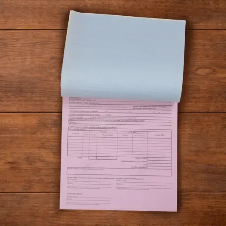 Paškopējošo veidlapu bloks ar atšķirtu zilu lapu un rozā kopiju uz koka fona