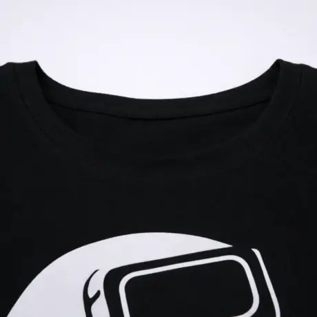 Melns T-krekls ar apdruku tuvplānā, redzams apaļš kakla izgriezums