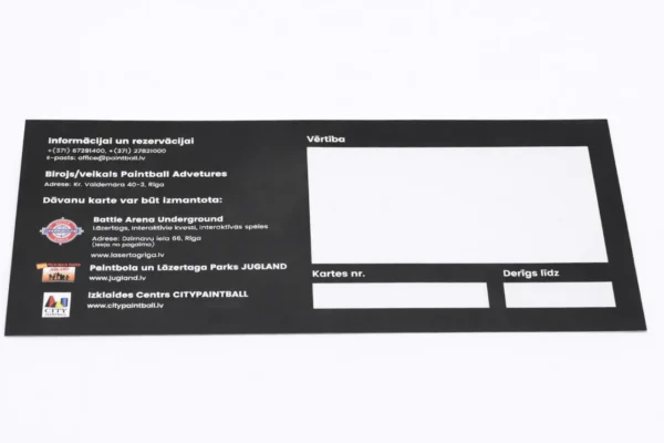 Melna drukāta dāvanu karte ar laukumiem vērtībai, kartes numuram un derīguma termiņam