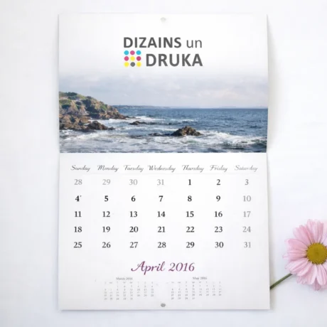 Перекидной настенный календарь с морским пейзажем и месяцем апрель рядом с розовым цветком