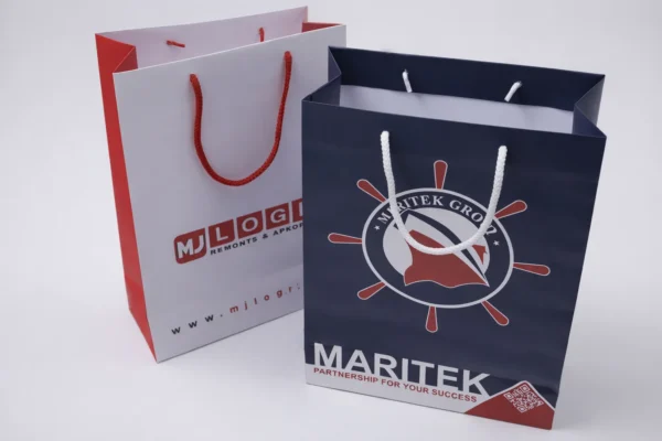 Divi papīra dāvanu maisiņi ar apdruku un auklas rokturiem