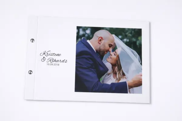 Individuāla kāzu fotogrāmata ar baltiem vākiem un jaunlaulāto foto