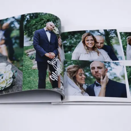 Atvērta kāzu fotogrāmata ar kvalitatīvu druku un laulāto pāra attēliem