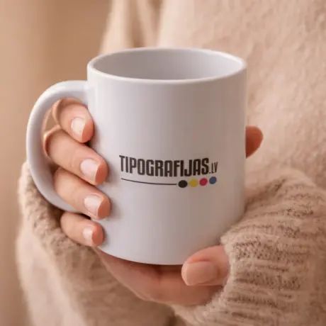 Balta keramikas krūze ar apdruku Tipografijas.lv rokās