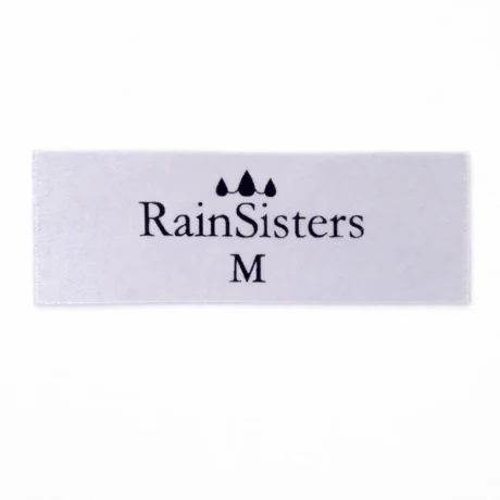 Balta satīna birka ar melnu druku, RainSisters logotipu un M izmēru